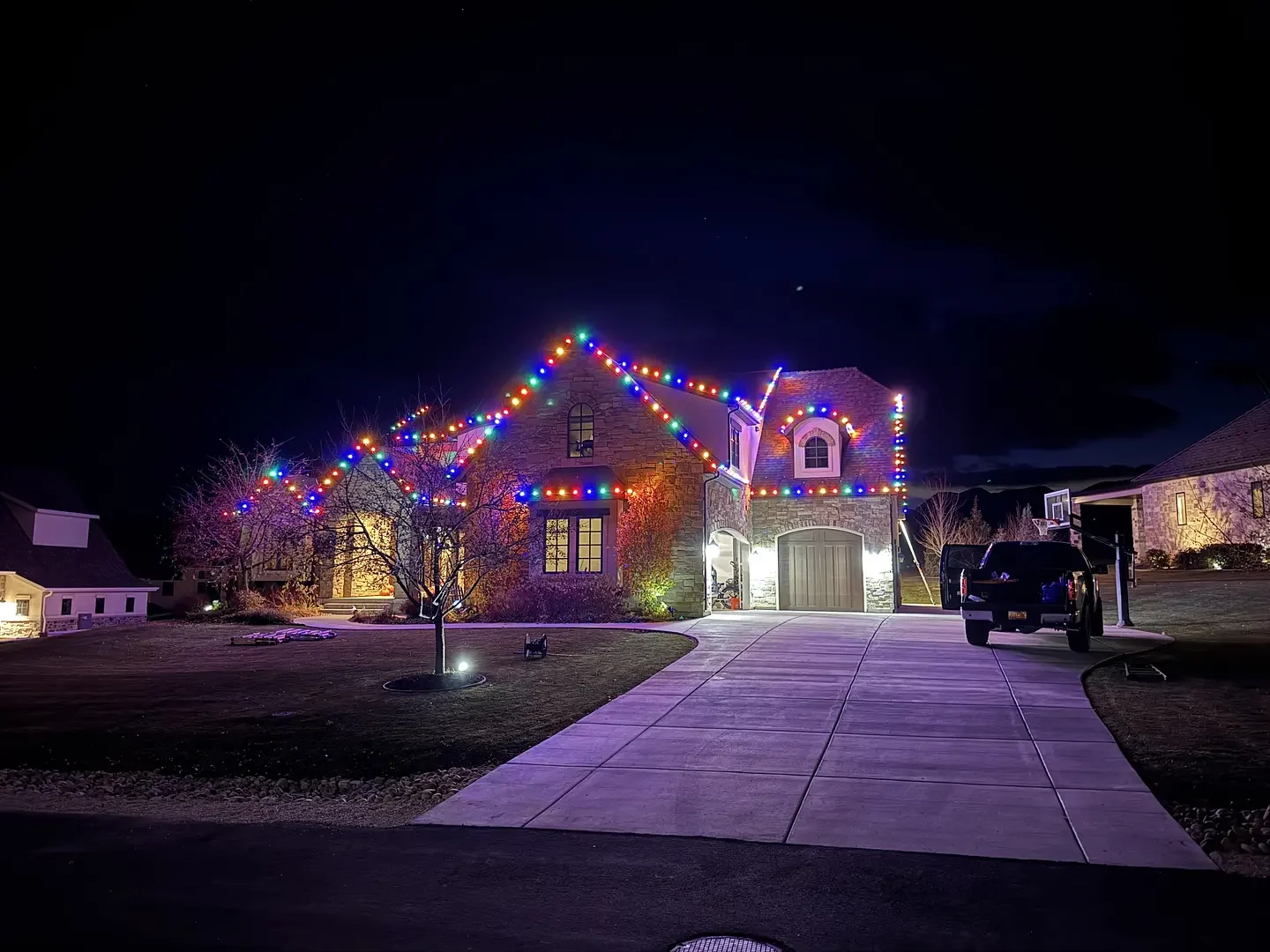 Stone home decorated with multicolored Christmas lights